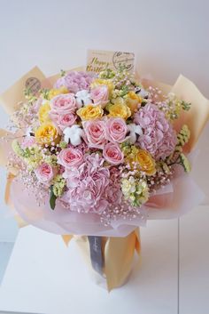 a bouquet of pink and yellow flowers on display