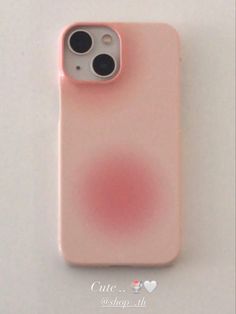 a pink iphone case sitting on top of a white table