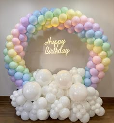 a birthday arch with balloons in pastel colors