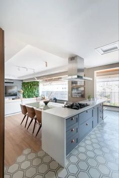 a kitchen with an island, stove and chairs