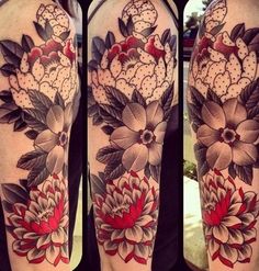 a woman's half sleeve with flowers and leaves on her left arm, the other half