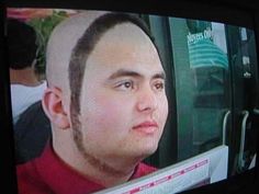 a man with a shaved head is on the television screen and has his hair cut back