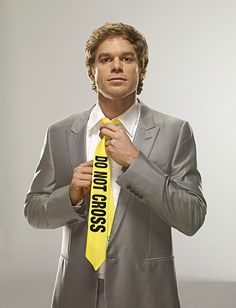 a man in a suit is holding a yellow tie with the words don't cross on it