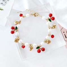 Indulge in some fruity charm with our Cherry Pearl Charm Bracelet! Adorned with sweet cherry and heart charms, this cute accessory adds a playful touch to any outfit. Complete with dainty pearls, it's the perfect blend of fun and elegance. Time to sweeten up your style! 🍒 Description: Material: Alloy Type: Bracelet Style: Fruit Cheap Cute Cherry Jewelry, Cheap Charm Bracelet For Valentine's Day, Cheap Sweet Style Charm Bracelet For Gifts, Cheap Handmade Cherry Jewelry, Cheap Handmade Cherry Colored Jewelry, Cheap Casual Red Charm Bracelet, Cheap Red Casual Charm Bracelet, Girly Bracelets Bead, Japanese Bracelet