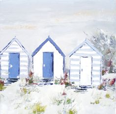 three white beach huts sitting in the sand