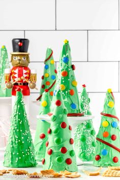 green christmas trees and nutcrackers are on the counter next to crackers