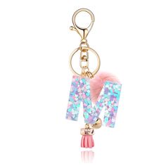 a keychain with the letter m on it and a pink pom - pom