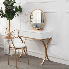 a white desk with a mirror, chair and potted plant next to it on the floor