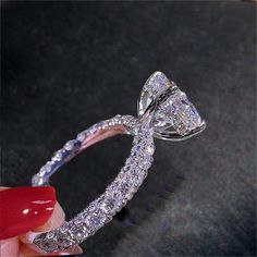 a close up of a person holding a diamond ring with the words jewelry sterling silver on it