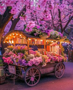 an old wooden cart filled with lots of flowers and books on top of a sidewalk