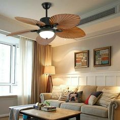 a living room with a couch, coffee table and ceiling fan in the middle of it