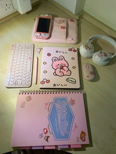 there is a notebook, cell phone and other items on the table with it's cover