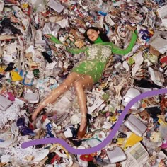 a woman laying on top of a pile of trash