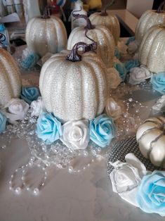 several white pumpkins with blue roses and pearls