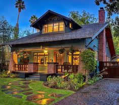 a house that is lit up at night with lights on the front and side windows