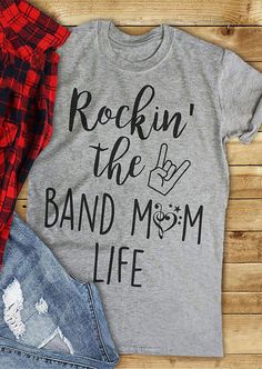 a t - shirt that says rockin'the band mom life next to ripped jeans