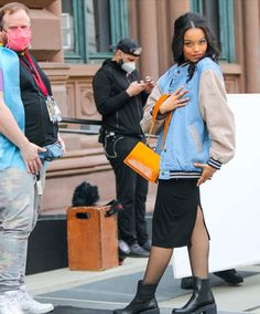 a woman wearing a face mask while standing on the street