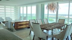 a dining room table with chairs and a chandelier hanging from the ceiling