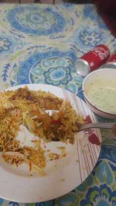 a plate with some food on it next to a bowl of soup and a can