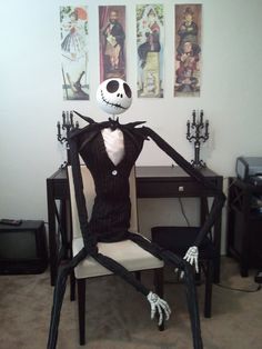 a skeleton sitting on top of a chair in front of a desk