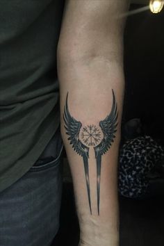 a person with a clock and wings tattoo on their arm