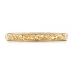 a gold wedding band with an intricate design