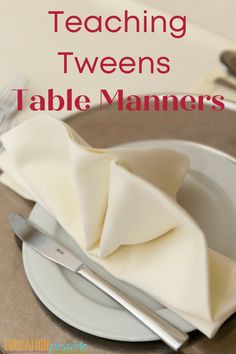 a white plate topped with napkins next to a knife and fork on top of a table