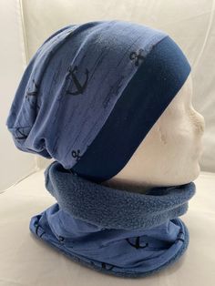 a blue hat and scarf on top of a mannequin's head with an anchor