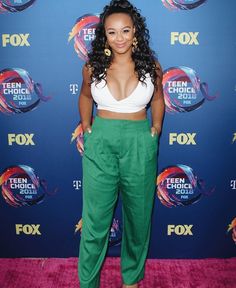 a woman in green pants and white crop top on the red carpet at an event