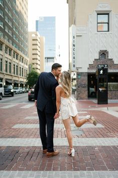 a man and woman are kissing on the street