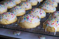 there are many cookies that have sprinkles on them and white frosting