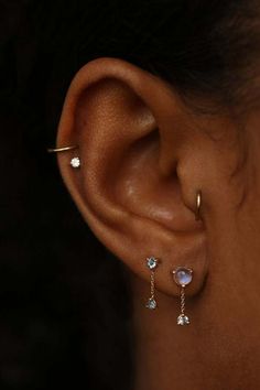 a close up of a person's ear with three different piercings on it