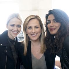 three women standing next to each other smiling