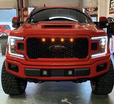 the front end of a red truck in a garage