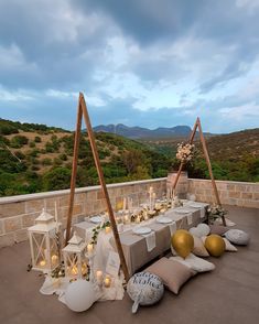 an outdoor table set up with candles and decorations