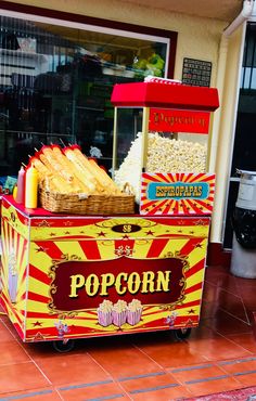 a popcorn machine sitting on top of a red and yellow tile floor next to a building