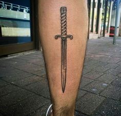 a man's leg with a tattoo on it and a knife in the middle