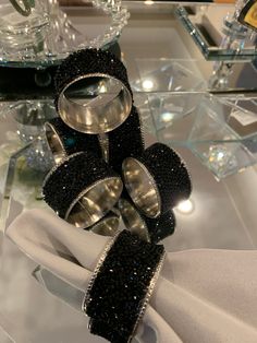 a pair of black and silver rings sitting on top of a white cloth covered table