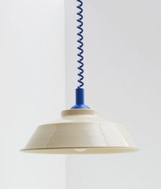 a white and blue light hanging from a ceiling fixture with a spiral design on it