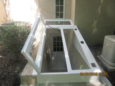 a window in the side of a house with an open door and windows on each side