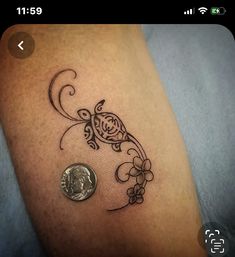 a small tattoo on the leg of a person with a penny in front of it