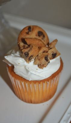 a cupcake with white frosting and chocolate chip cookies on top