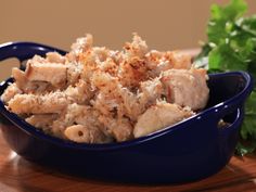 a blue bowl filled with food sitting on top of a wooden table