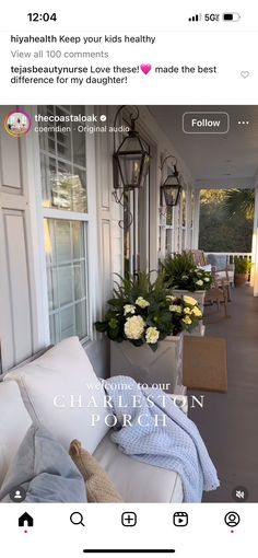 a white couch sitting on top of a wooden floor next to a window filled with flowers