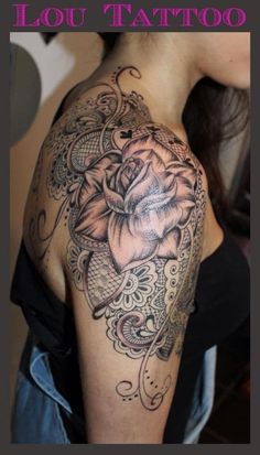 the back of a woman's shoulder with flowers on it and an ornate design