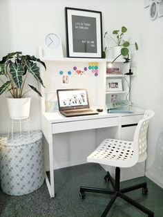 a white desk topped with a laptop computer next to a potted plant