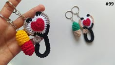 two crocheted keychains are being held by someone's hand,