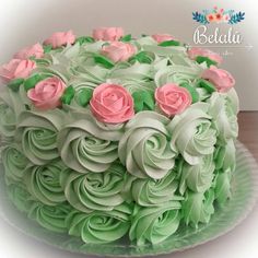 a green cake with pink roses on top