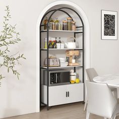 a white dining room table and chairs in front of an arch - shaped bookcase