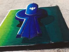 a blue hat on top of a green and white parking lot with the word's logo painted on it